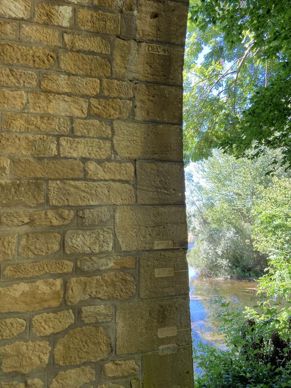 Repères de crues gravés sur une pile du pont de Siorac